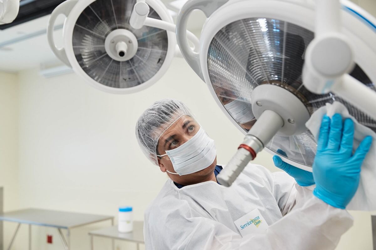 Cleaning staff wiping medical equipment